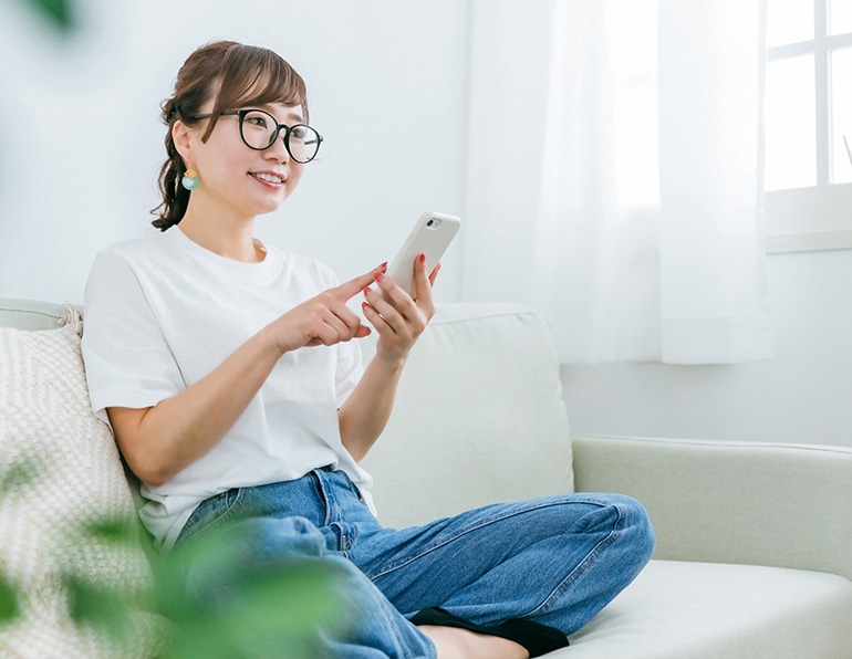 スマホを触る女性の画像